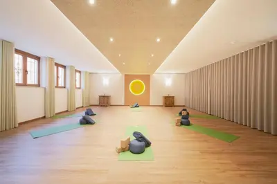 a room with people sitting in a yoga pose in a room at Vegan Hotel La Vimea in Naturno