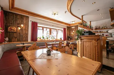 a restaurant with a wooden table and chairs at Hotel Siror in Fiera di Primiero