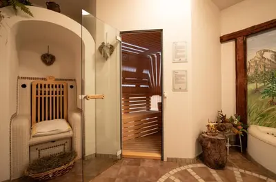 a hallway with a door to a bathroom with a tub at Hotel Siror in Fiera di Primiero