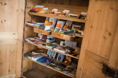 a book shelf filled with books in a wooden room at Garni Hotel Katzenthalerhof in Lana