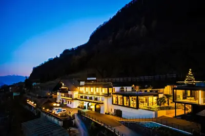 a building with a christmas tree in front of a mountain at Garni Hotel Katzenthalerhof in Lana