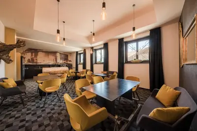 a waiting room with tables and chairs at Garni Hotel Katzenthalerhof in Lana