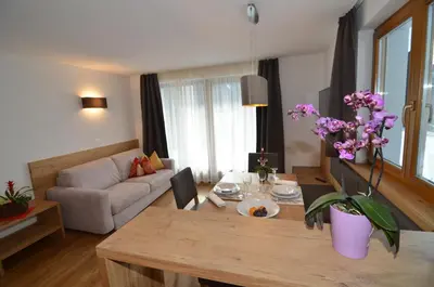 a living room with a table and a couch at Villa Paröis in La Valle