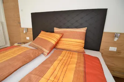 a bedroom with two beds with colorful blankets and pillows at Villa Paröis in La Valle
