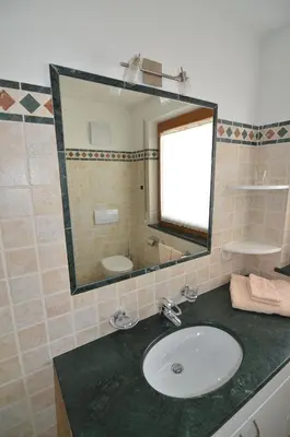 a bathroom with a sink and a mirror at Villa Paröis in La Valle