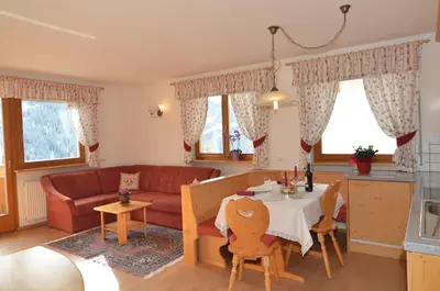a living room with a red couch and a table at Villa Paröis in La Valle