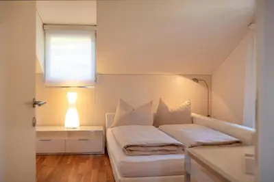 a bedroom with a bed with white sheets and a lamp at Frühmesserhaus Refugium zu Sanct Kassian in Lagundo