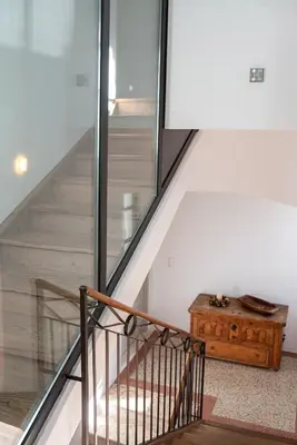a staircase with a glass railing and a wooden table at Frühmesserhaus Refugium zu Sanct Kassian in Lagundo