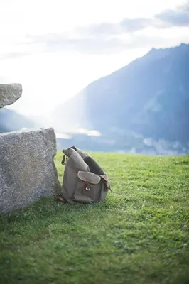 a backpack sitting on the grass next to a rock at Ferienwohnung - THOLER in Lagundo