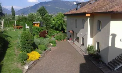 a house with a walkway next to a yard at Ferienwohnungen St. Michael in Appiano sulla Strada del Vino