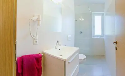 a white bathroom with a sink and a toilet at Ferienwohnungen St. Michael in Appiano sulla Strada del Vino
