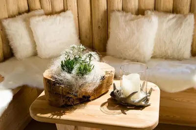a woman sitting on a window sill on a building at Hotel Santner Alpine Sport & Relax in Alpe di Siusi