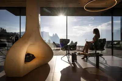 a restaurant with a bar with chairs and a table at Hotel Santner Alpine Sport & Relax in Alpe di Siusi