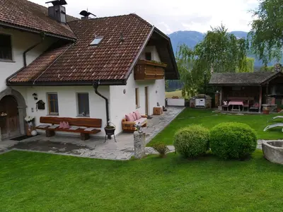 a house with a yard with benches and a house at Stockerhof in San Lorenzo di Sebato