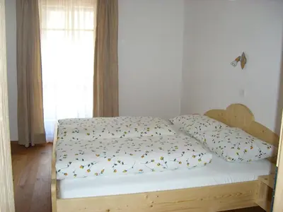 a bedroom with a bed with a wooden bed frame at Stockerhof in San Lorenzo di Sebato