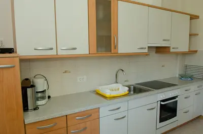 a kitchen with white cabinets and a sink at Stockerhof in San Lorenzo di Sebato