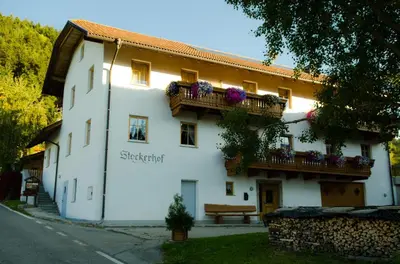 a white building with balconies and flowers on it at Stockerhof in San Lorenzo di Sebato