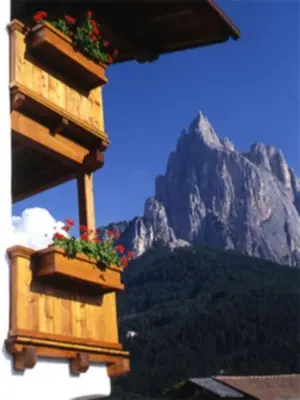 two flower boxes on a building with a mountain in the background at Residence Kampidell in Siusi