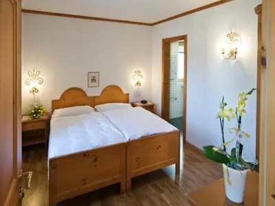 a bedroom with a large bed with white sheets at Residence Kampidell in Siusi