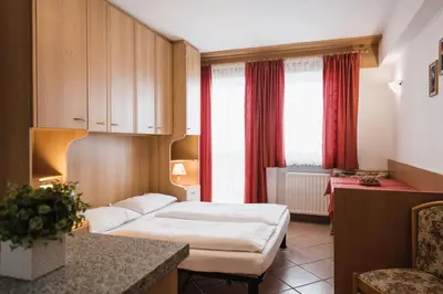a hotel room with a bed and a desk at Apparthotel Sellaronda in Arabba