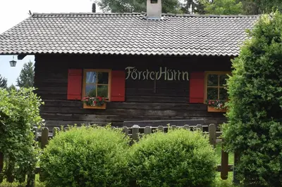 a log cabin with red doors and flowers in the window at Brünnl's Försterhütte in Parcines