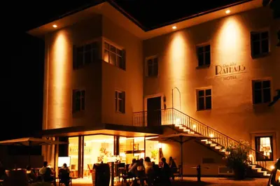 people sitting outside of a building at night at Das Alte Rathaus in Egna