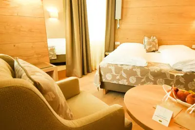 a hotel room with a bed and a table and chairs at Das Alte Rathaus in Egna
