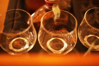 three empty wine glasses sitting next to a bottle at Das Alte Rathaus in Egna