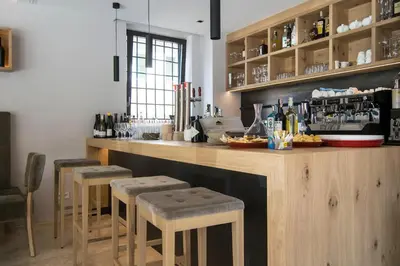 a bar in a restaurant with stools and a counter at Das Alte Rathaus in Egna