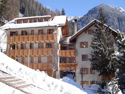 a large building in the snow with snow at Casa Italo in Canazei