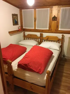 a bedroom with two beds with red pillows on them at Casa Italo in Canazei