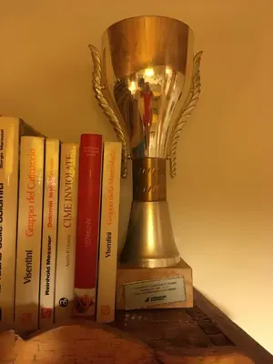 a trophy sitting on a shelf next to books at Casa Italo in Canazei