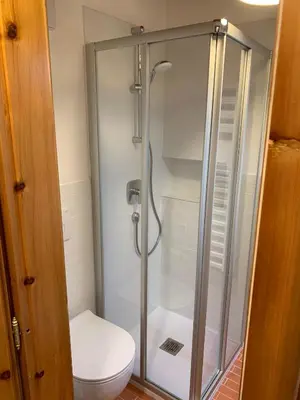 a shower stall in a bathroom with a toilet at Casa Italo in Canazei