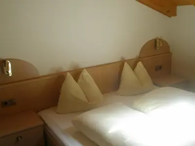 a room with a bed with white pillows on it at Boarhof Appartaments in San Giacomo Val di Vizze