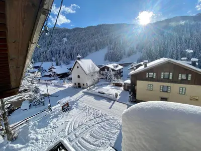 a view of a snow covered village with a ski lift at Hotel B&B Lorenzini Ski in Selva di Cadore