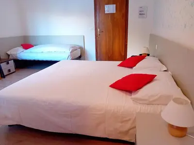 a bedroom with two white beds with red pillows at Hotel B&B Lorenzini Ski in Selva di Cadore