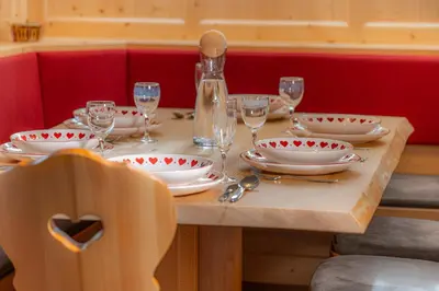 a wooden table with plates and wine glasses on it at Gabriel in Ortisei