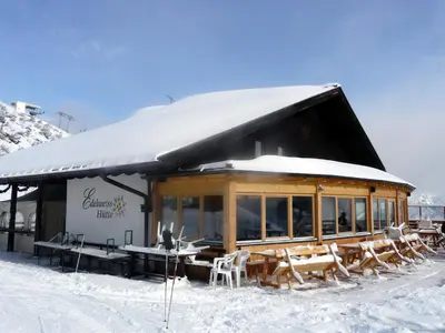 a restaurant with tables and chairs in the snow at Edelweisshütte Ladurns in Fleres