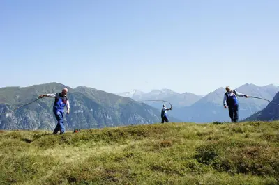 a house on a green hill with mountains in the background at Edelweisshütte Ladurns in Fleres