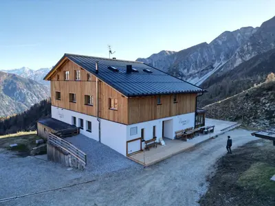 a bedroom with a bed with a wooden wall at Edelweisshütte Ladurns in Fleres