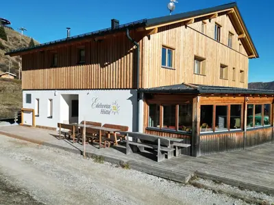 a building with benches on the side of it at Edelweisshütte Ladurns in Fleres