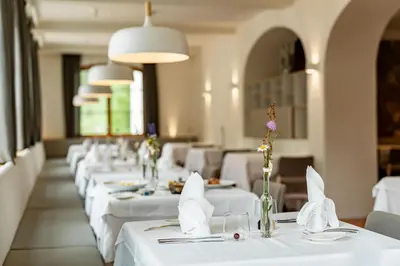 a row of tables with white table cloths at Zum Hirschen Boutique Hotel Val di Non in Unsere Liebe Frau im Walde