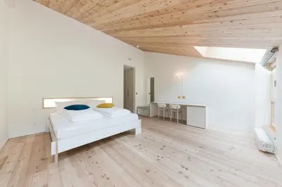 a white room with a bed and a table at Zum Hirschen Boutique Hotel Val di Non in Unsere Liebe Frau im Walde