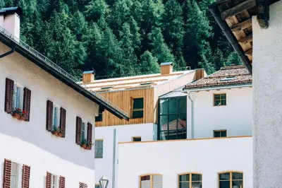 a group of buildings with trees in the background at Zum Hirschen Boutique Hotel Val di Non in Unsere Liebe Frau im Walde