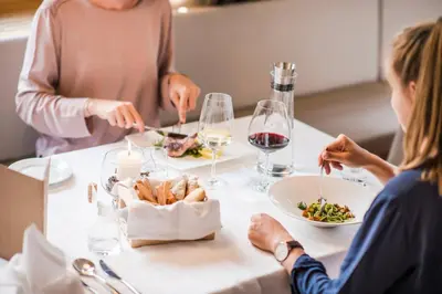 a group of people sitting around a table eating food at Zum Hirschen Boutique Hotel Val di Non in Unsere Liebe Frau im Walde