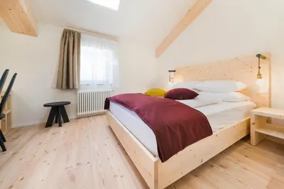 a bedroom with a large bed with white sheets and pillows at Zum Hirschen Boutique Hotel Val di Non in Unsere Liebe Frau im Walde