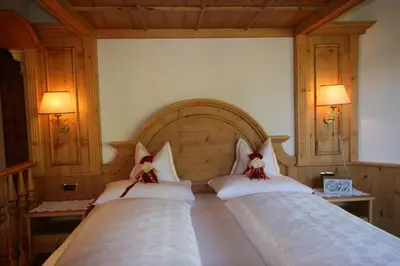 a bedroom with two beds with white pillows at Hotel Al Sonnenhof in San Vigilio Di Marebbe