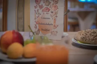 a table with a plate of food and a plate of fruit at Hotel Al Sonnenhof in San Vigilio Di Marebbe