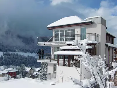 a building with snow on the side of it at Villa Quenz Family Suites in Ortisei