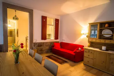 a white building with a balcony on top of it at Villa Quenz Family Suites in Ortisei